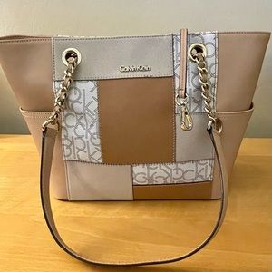 Calvin Klein shoulder tote with magnetic snap closure. Tan and beige vinyl.